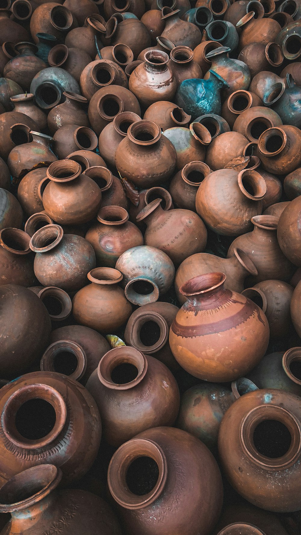 a large pile of brown vases sitting on top of each other
