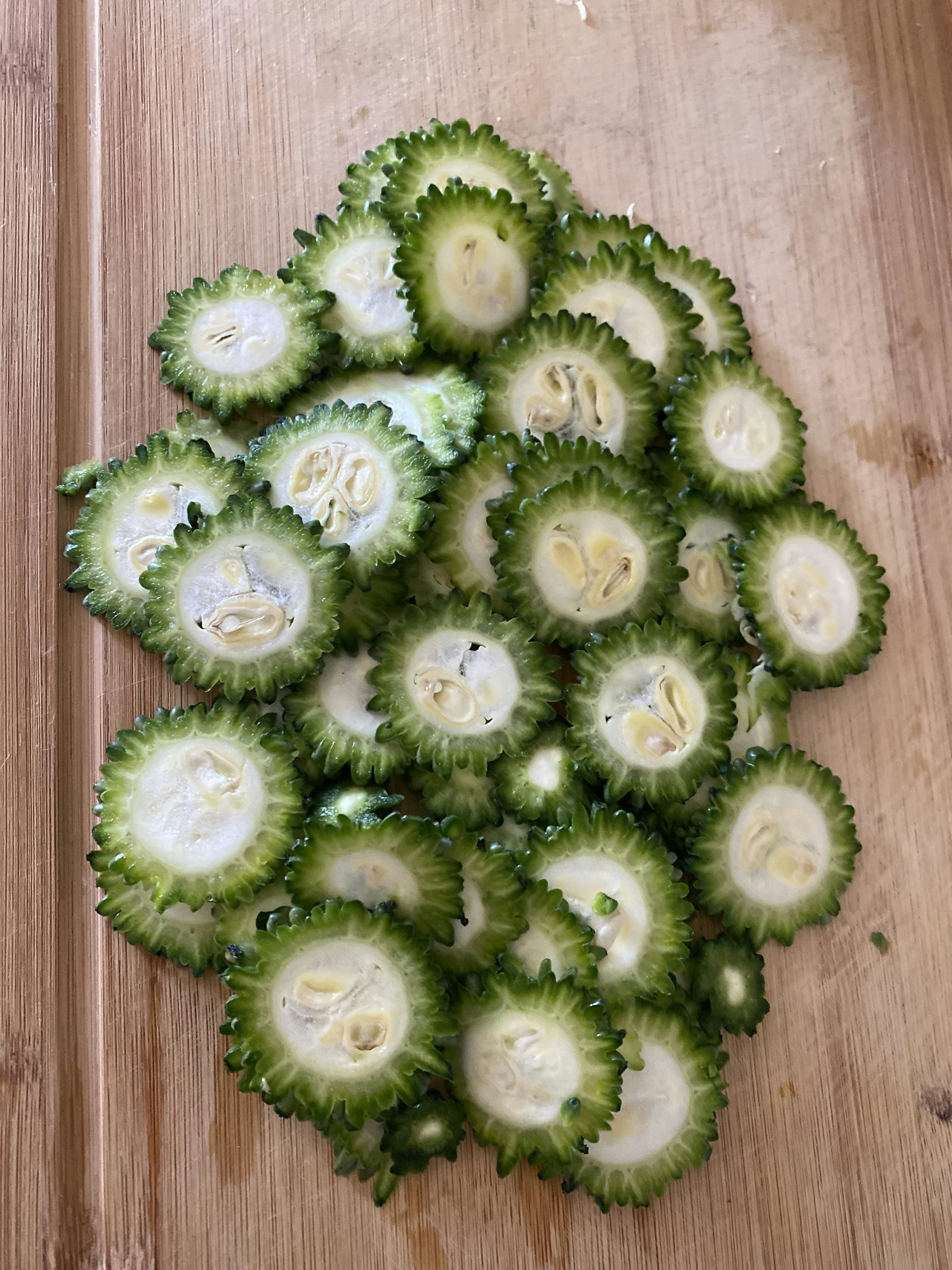 Fresh bitter gourd vegetables on a dark wooden surface, natural lighting