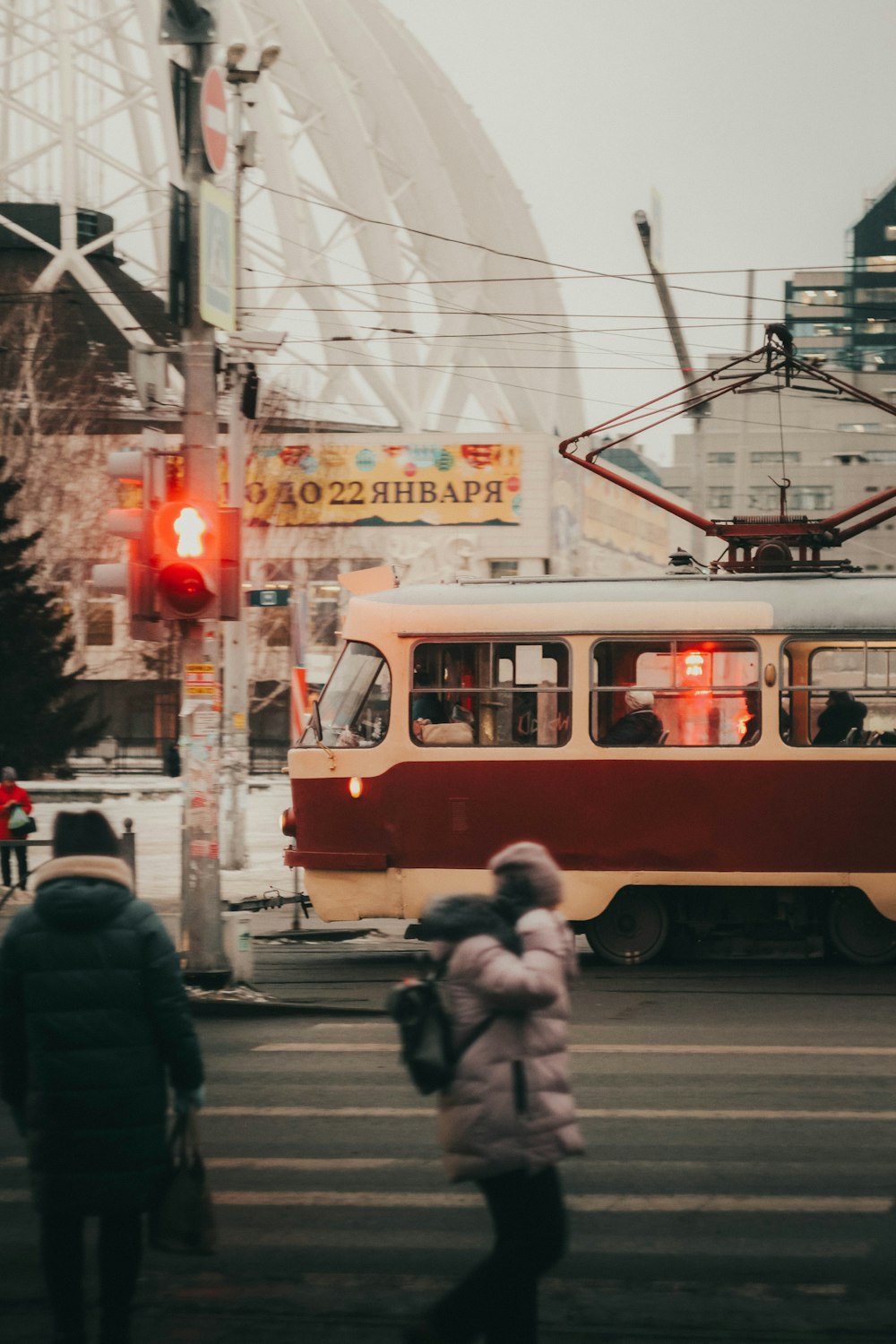 a red and white bus driving down a street next to tall buildings