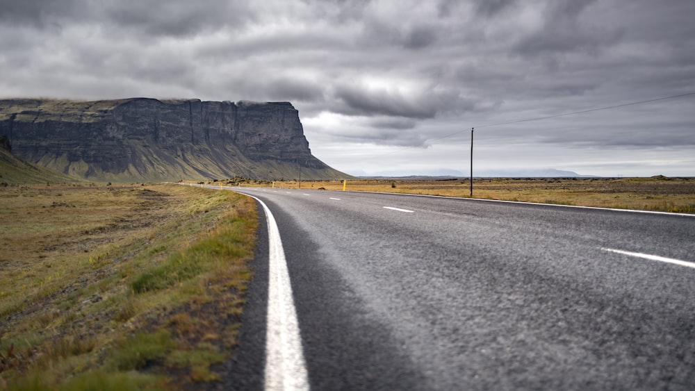 an empty road with a mountain in the background