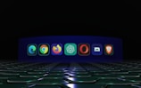A row of browser and application icons is displayed against a dark background with a futuristic, illuminated floor. Each icon is distinct and represents a different software or web browser.