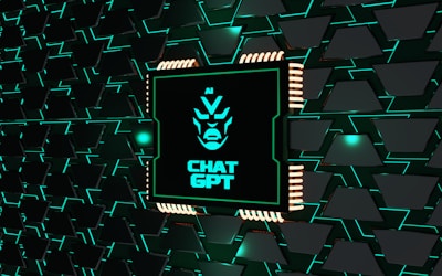 A stylized representation of a computer chip is integrated into a black and teal geometric background. The chip features a minimalist, futuristic face design along with the text 'CHAT GPT' in bold, glowing teal. The background consists of repeating black shapes outlined in teal, creating a high-tech, digital atmosphere.