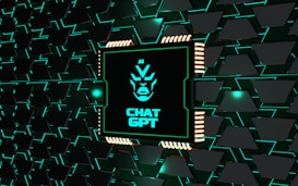 A stylized representation of a computer chip is integrated into a black and teal geometric background. The chip features a minimalist, futuristic face design along with the text 'CHAT GPT' in bold, glowing teal. The background consists of repeating black shapes outlined in teal, creating a high-tech, digital atmosphere.