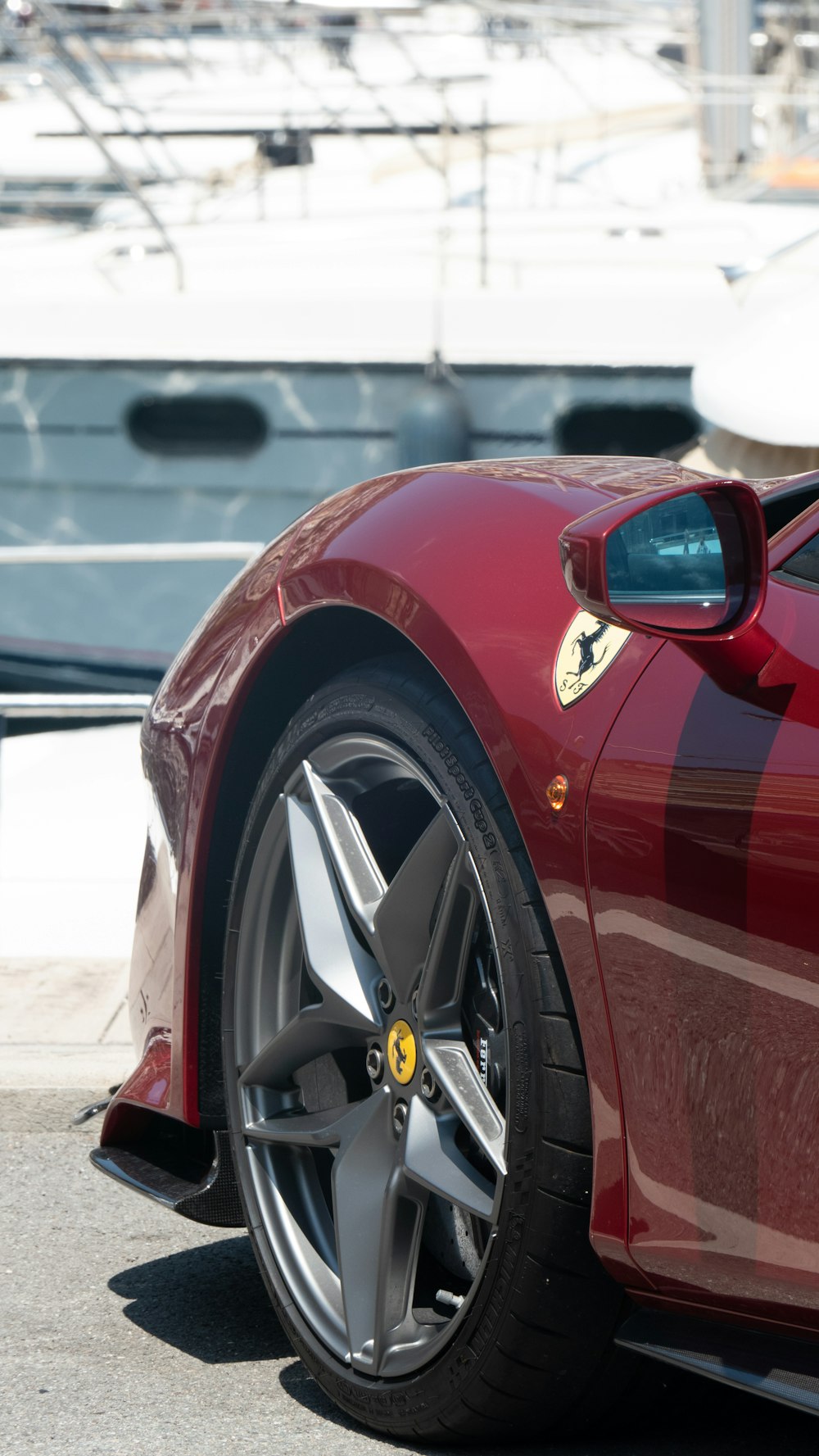 a red sports car parked in front of a boat