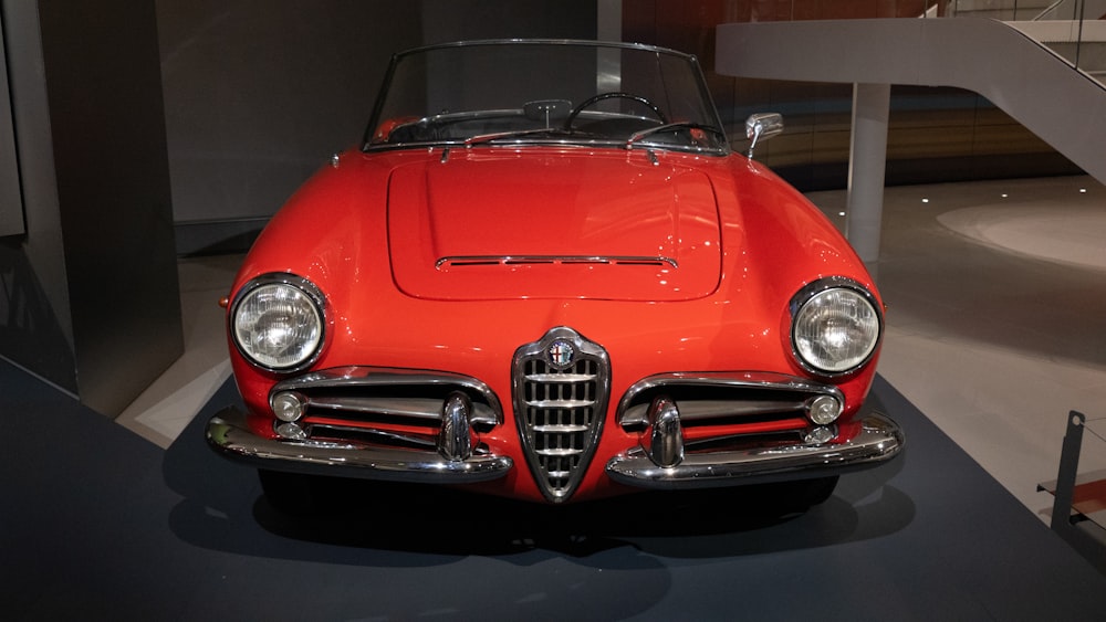 a red car is on display in a museum