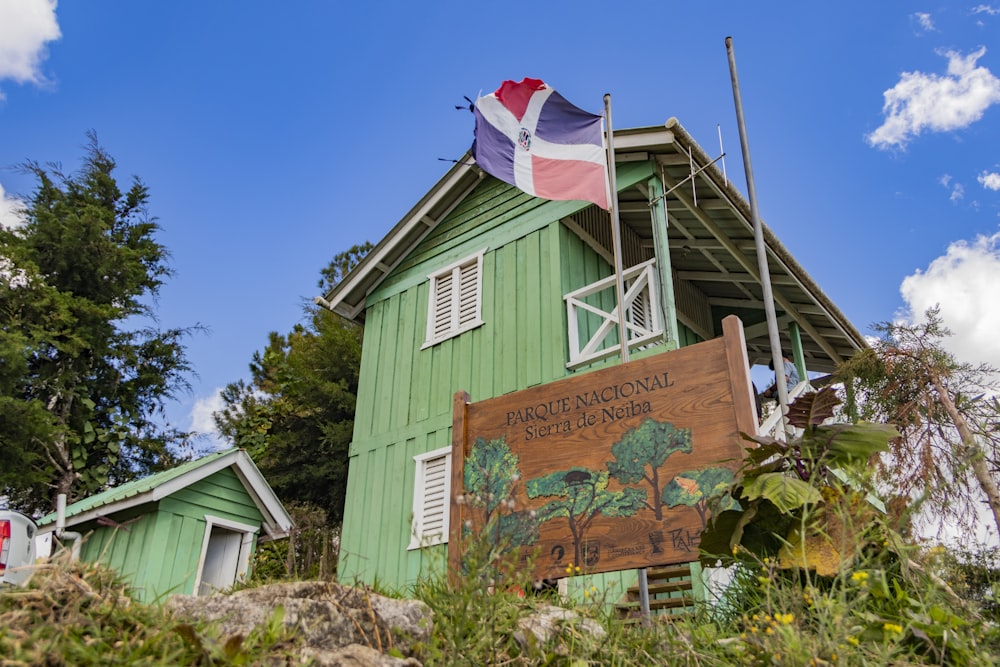 a green building with a flag on top of it