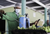 Technician adjusting aerial spraying equipment beside a coconut plantation.