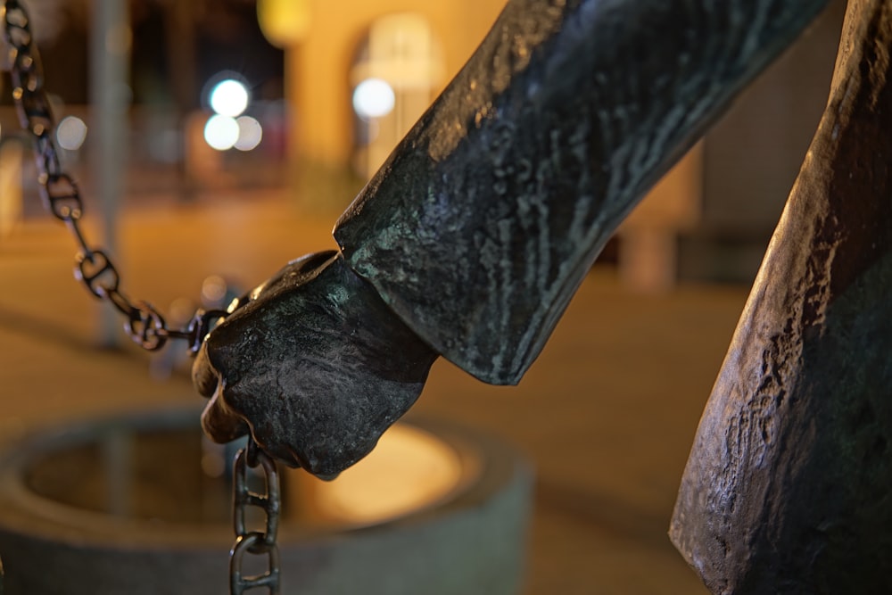 a close up of a statue of a person holding a chain