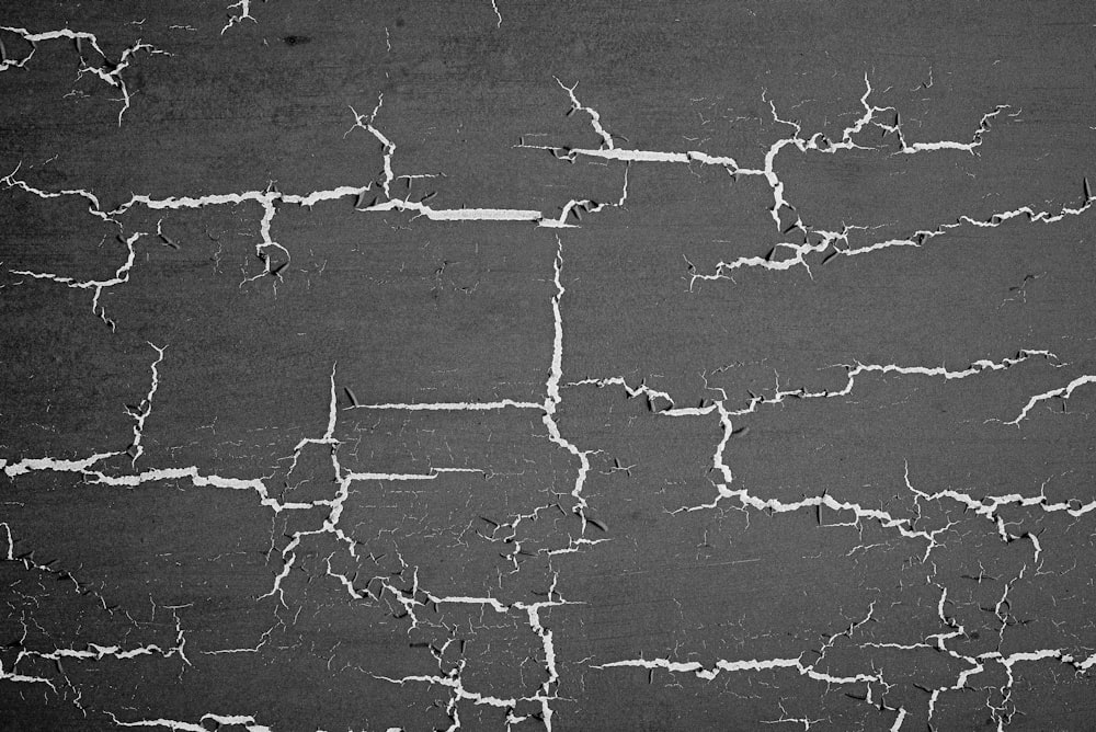 a black and white photo of a cracked wall