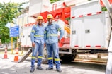 a couple of men standing next to each other in front of a truck