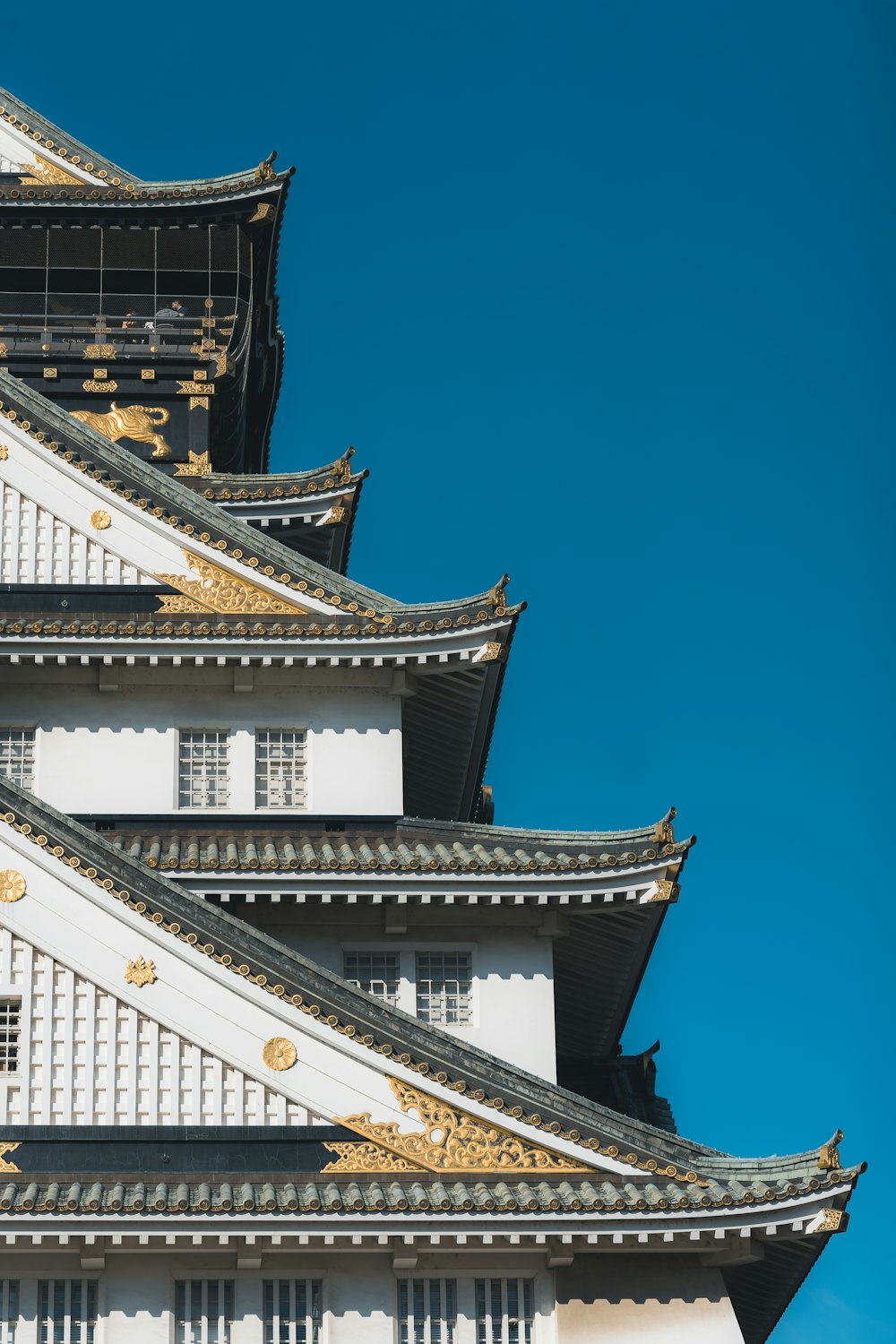 a tall white and gold building with a blue sky in the background