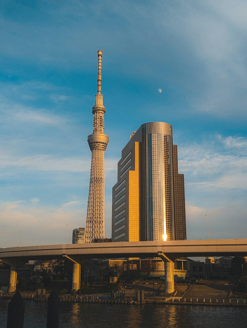 a tall building sitting next to a river under a blue sky