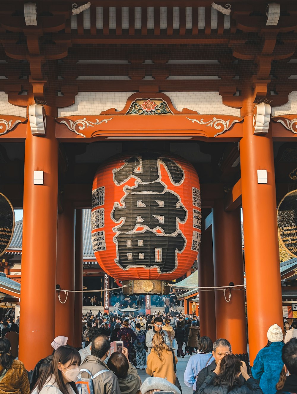 a group of people standing in front of a tall orange building