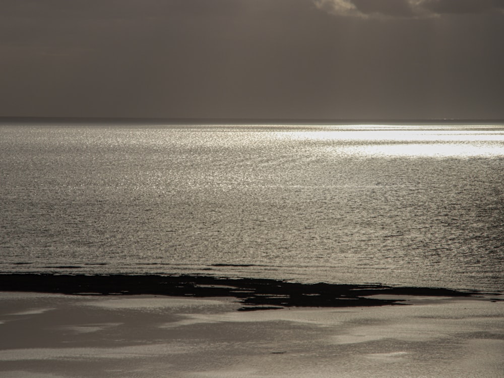 a large body of water sitting under a cloudy sky