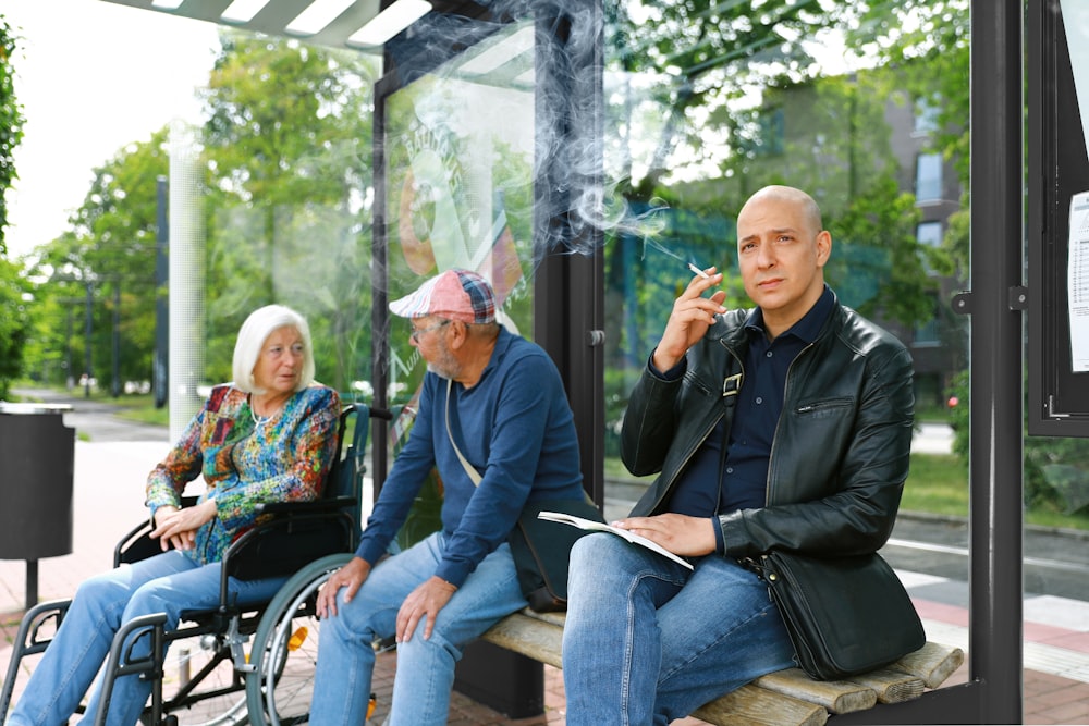 a man sitting on a bench next to a woman smoking a cigarette