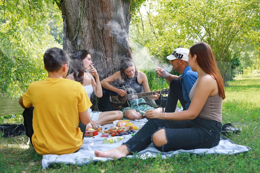 a group of people sitting around a tree