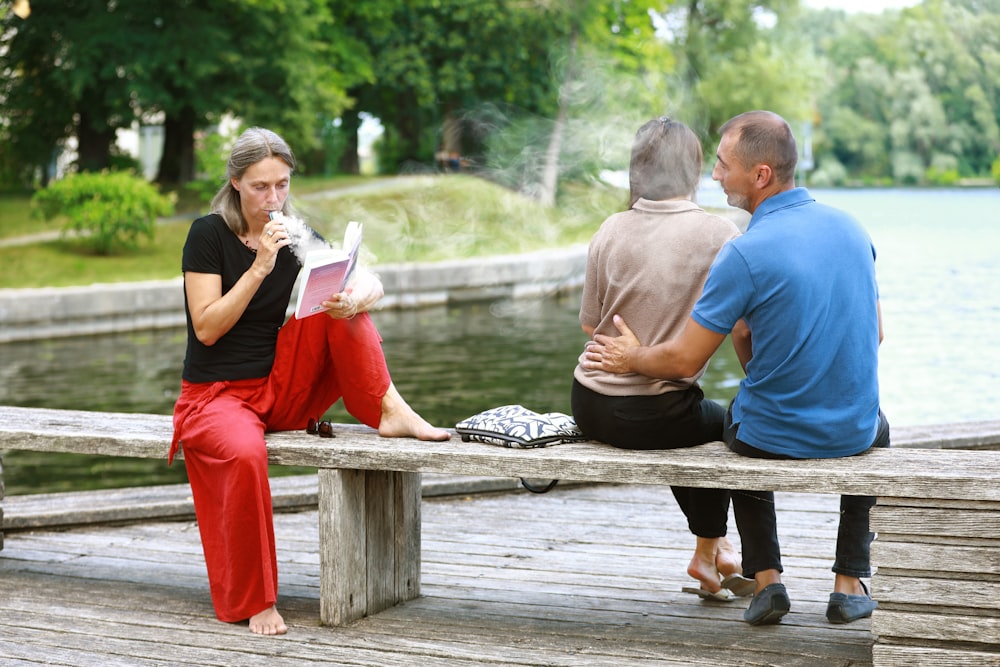 a couple of people sitting on top of a wooden bench