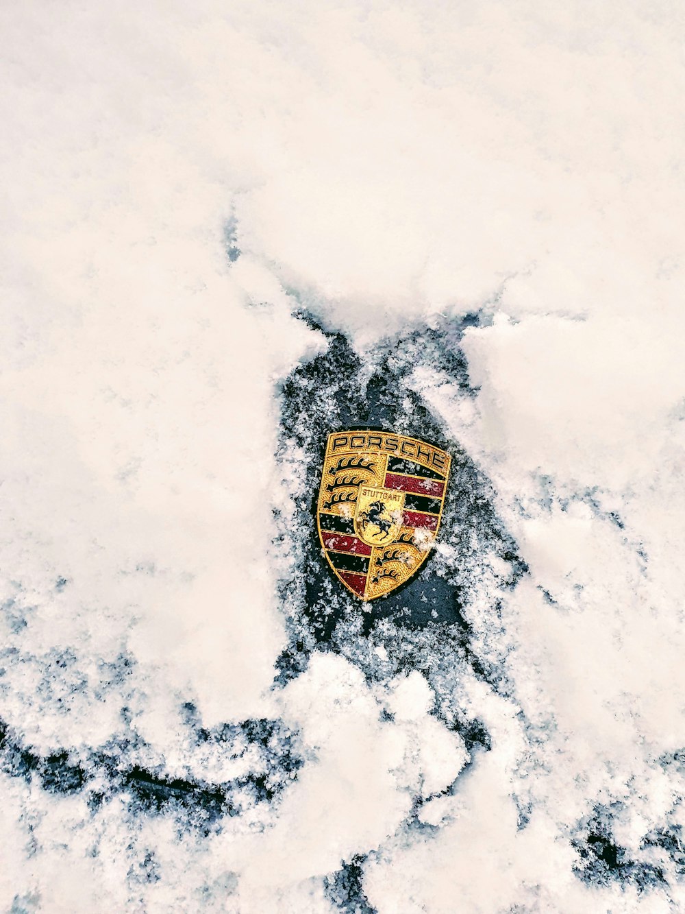 a porsche emblem is seen in the snow