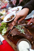 Chef carefully slicing a juicy rib eye steak in the stylish Argentine grill restaurant.