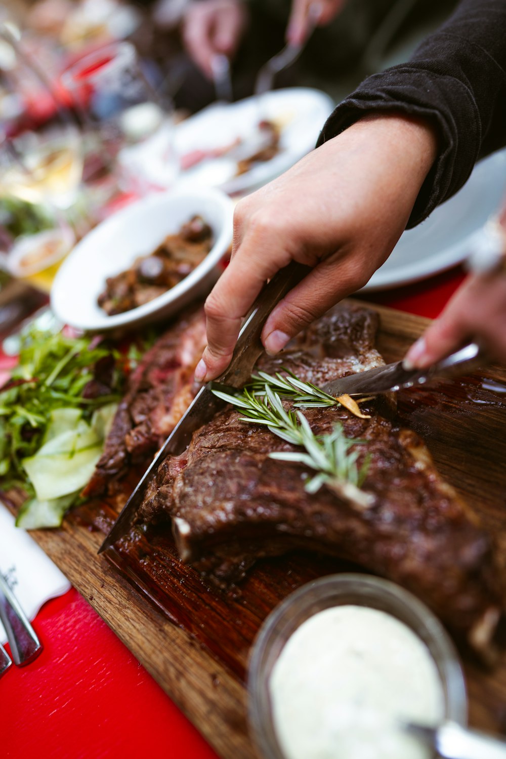 a person cutting a piece of meat on a cutting board