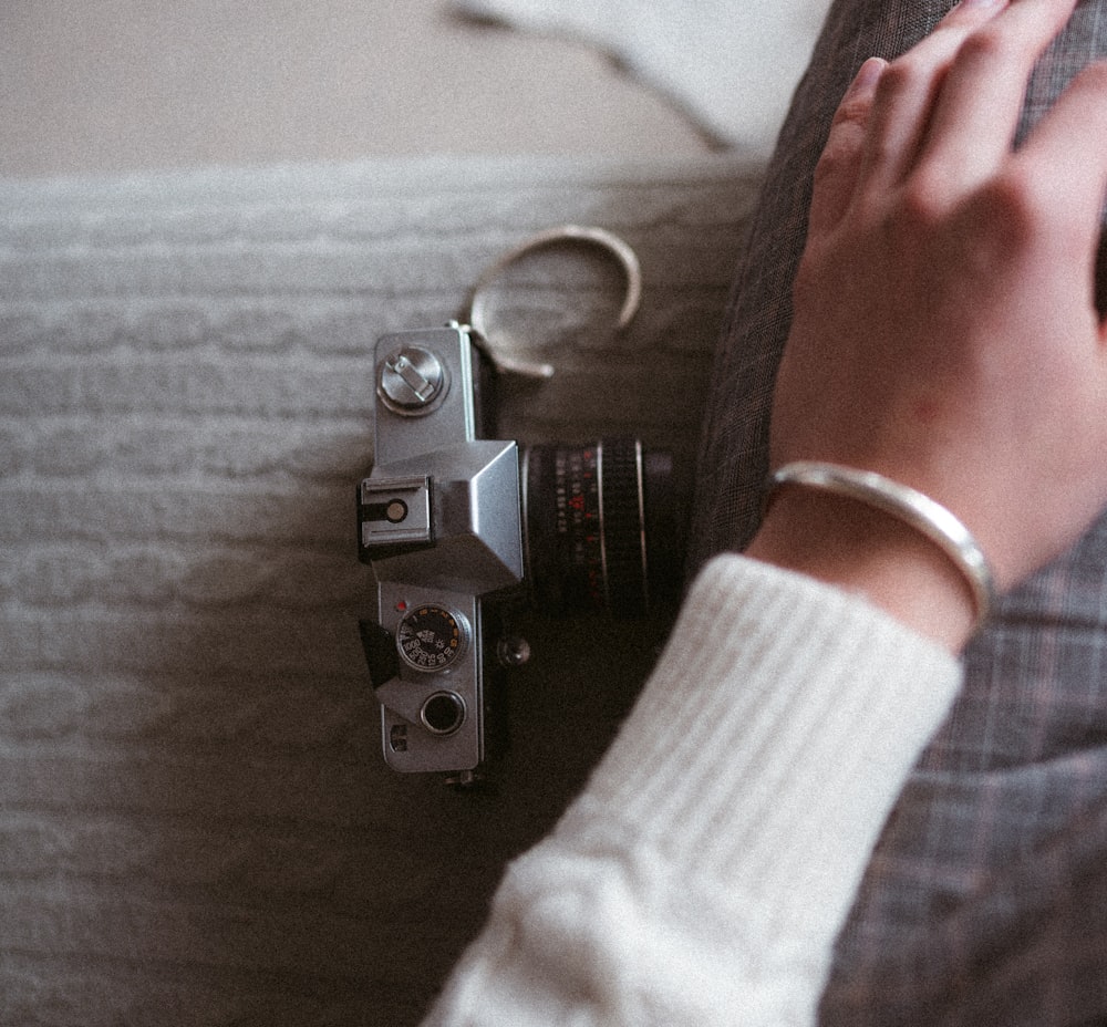 a person holding a camera next to a keychain