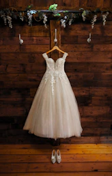 a dress hanging on a wooden wall next to a pair of shoes