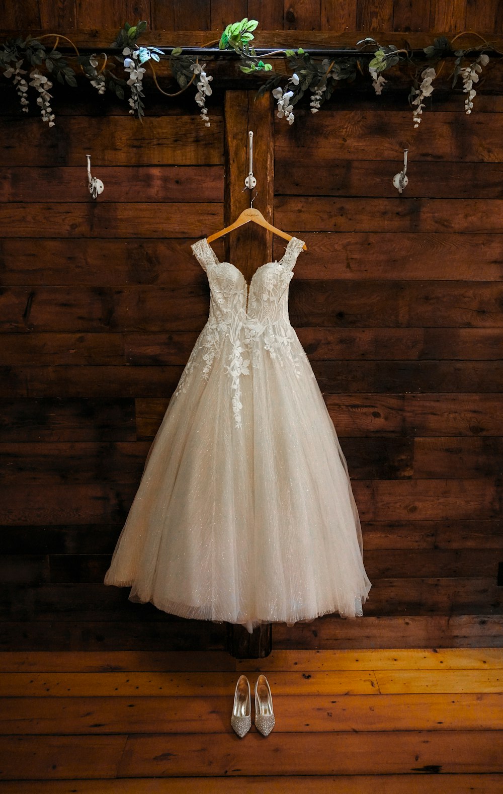 a dress hanging on a wooden wall next to a pair of shoes