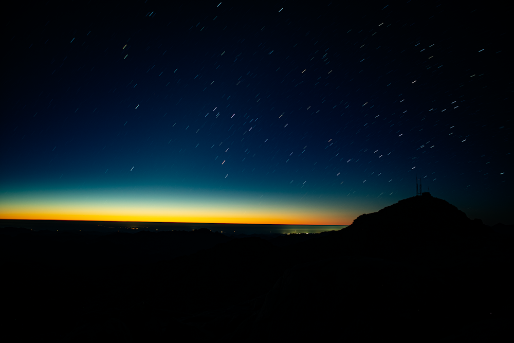 Un cielo nocturno con estrellas sobre una montaña