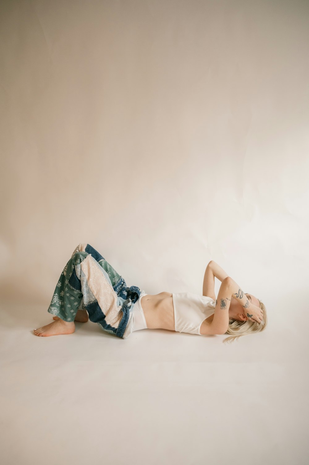 a woman laying on her back on a white background