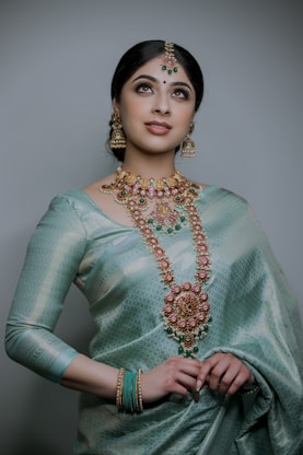a woman wearing a green sari and jewelry