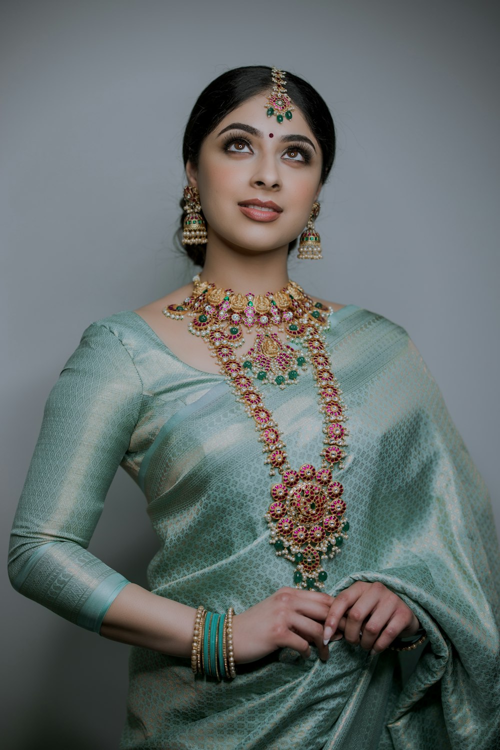 Une femme portant un sari vert et des bijoux