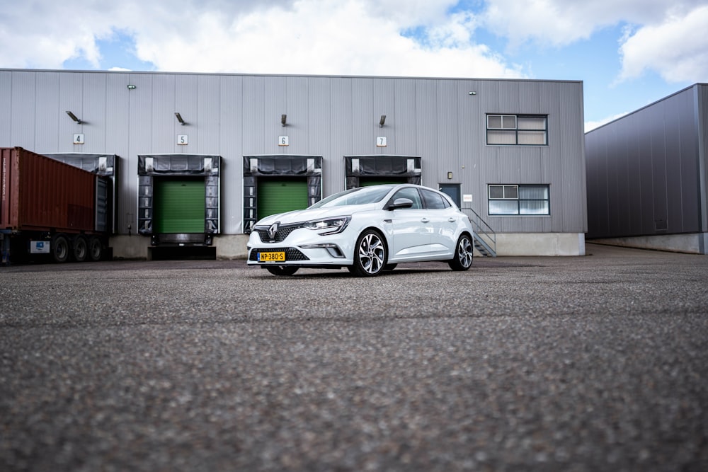 a white car parked in front of a building