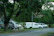 Rescue tow truck assisting a broken-down vehicle on a winding road surrounded by greenery.