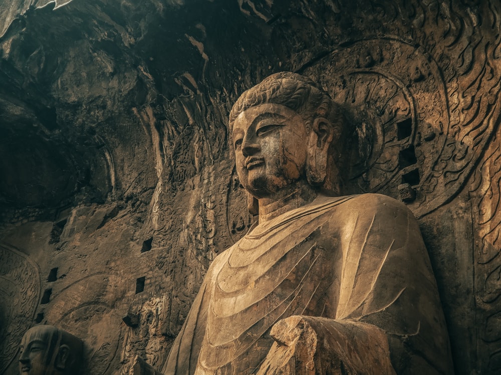 a large statue of a buddha in a cave