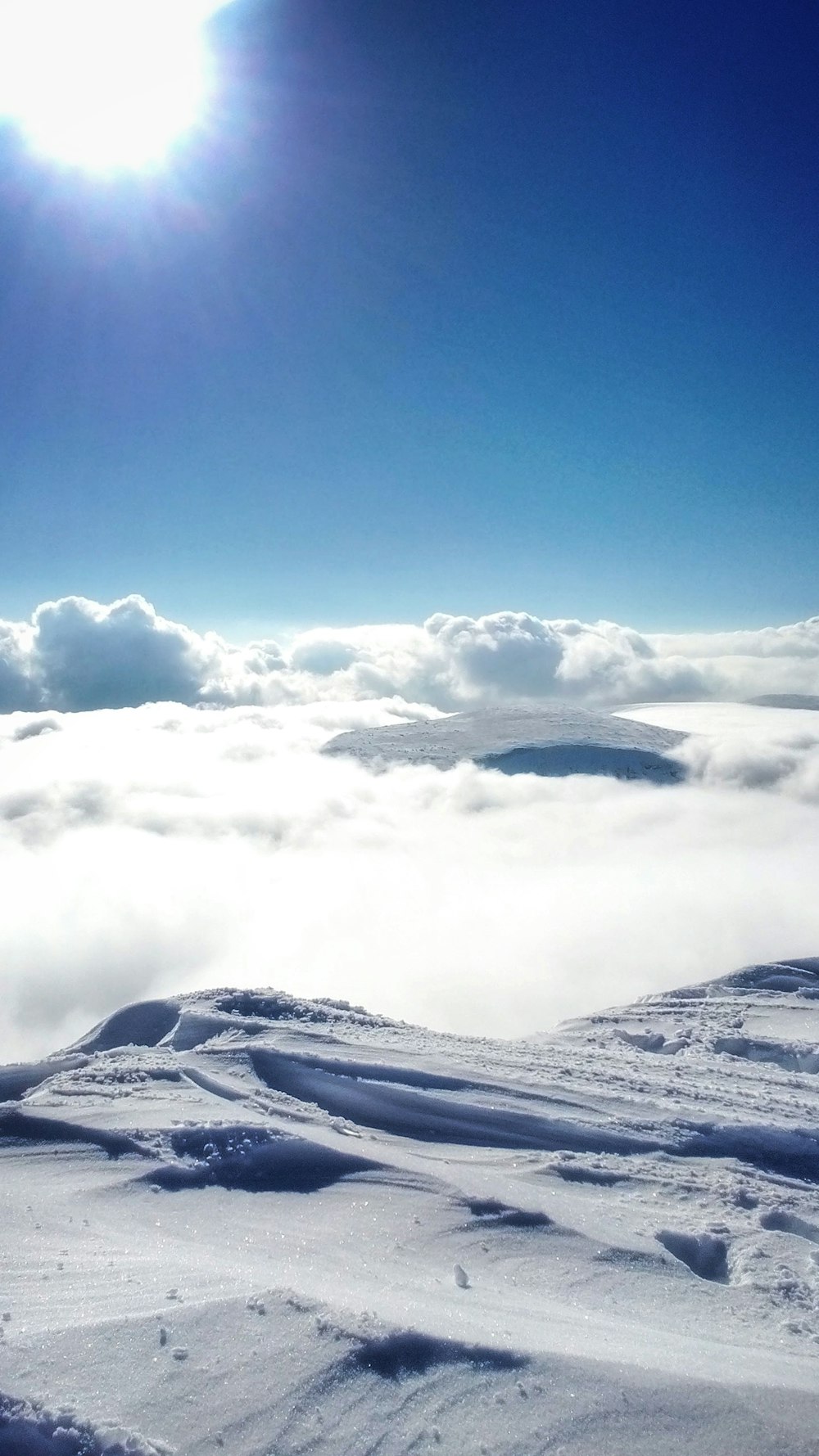 the sun is shining above the clouds in the sky