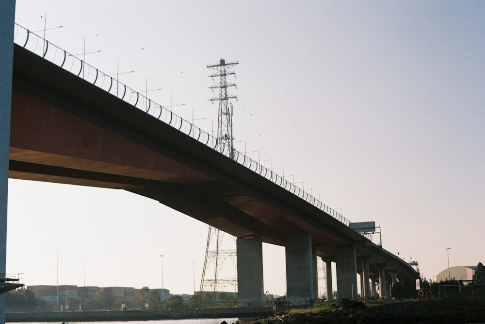 a bridge over a body of water with a tower in the background