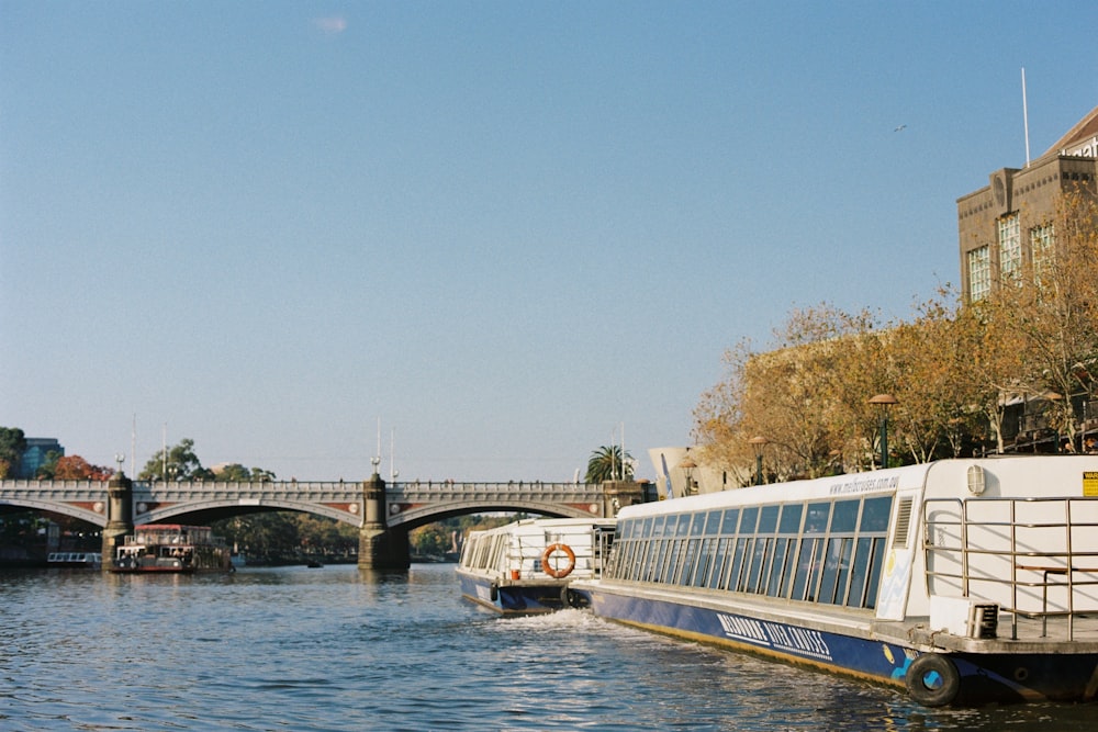 a boat traveling down a river next to a bridge