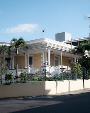 A friendly real estate agent smiling warmly while standing in front of a charming Central Florida home on a sunny day.
