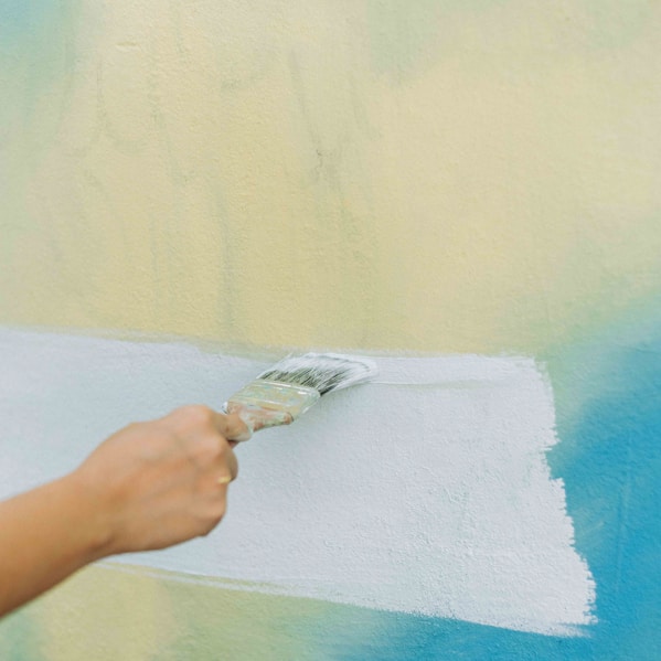 a person painting a wall with a paint roller