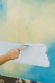 a person painting a wall with a paint roller