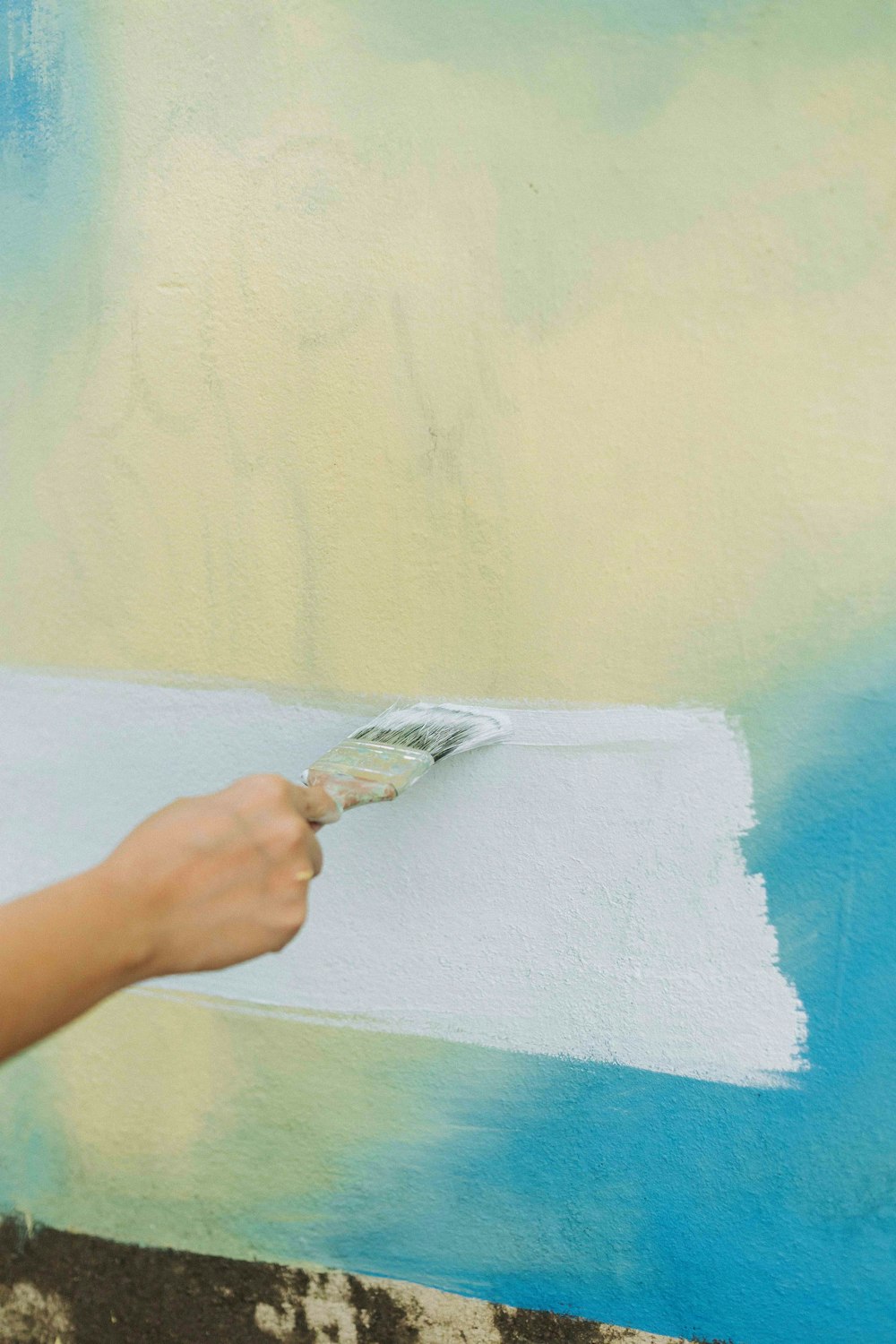 a person painting a wall with a paint roller