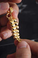 Artisan hands delicately crafting a fine gold pendant under warm lighting.