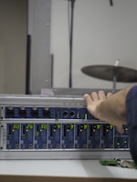 Technician adjusting audio equipment during a live recording session.