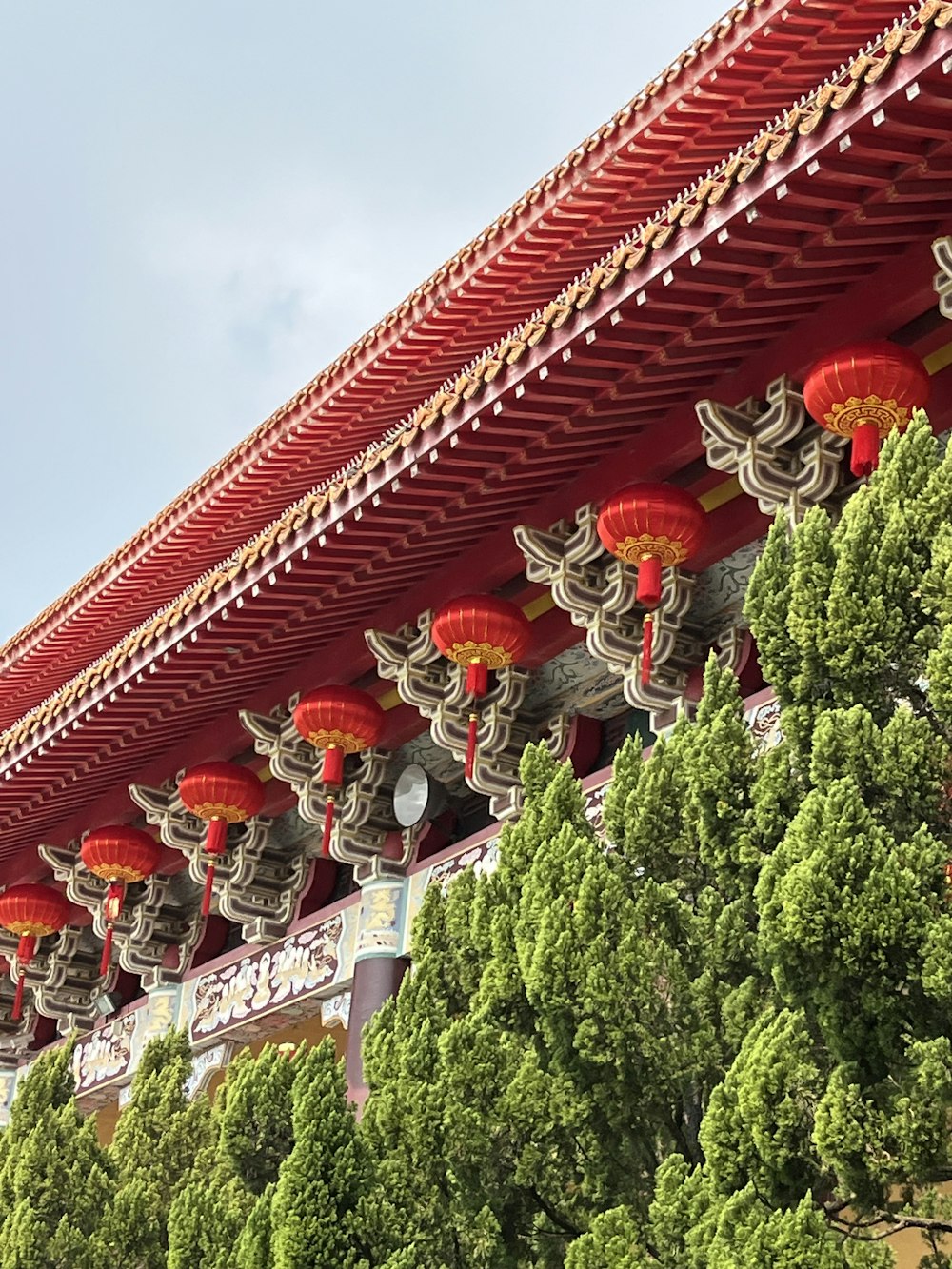 a building with red lanterns hanging from it's roof