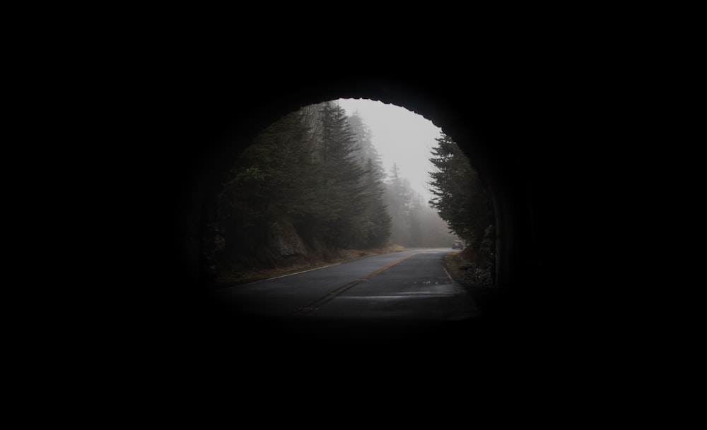 uma vista de uma estrada através de um túnel escuro
