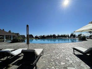 Inviting pool area with clear blue water and lounge chairs under the sun