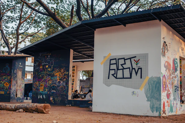 An outdoor art workshop where participants paint murals reflecting cultural stories and shared experiences.