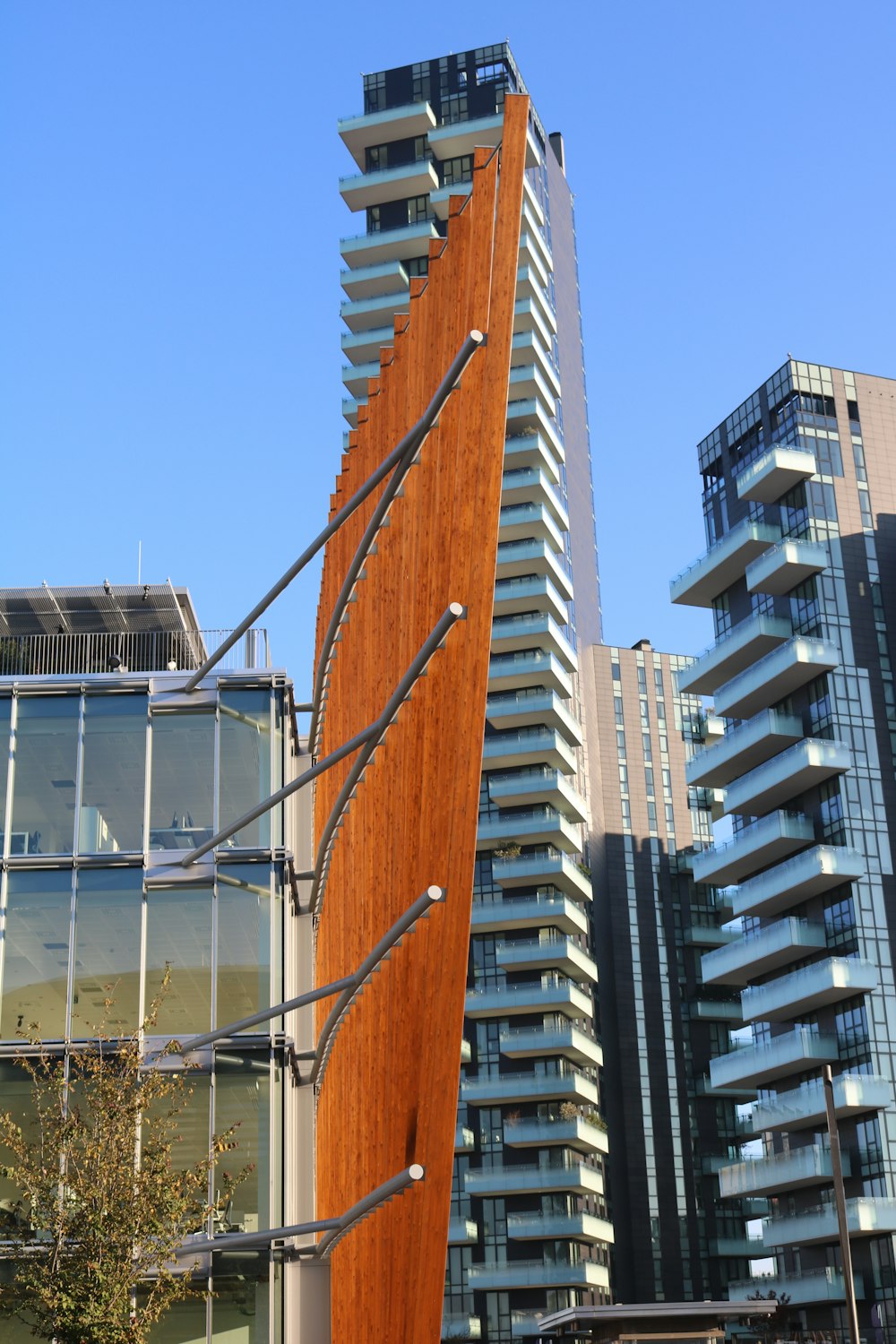 a tall building with a wooden sculpture in front of it