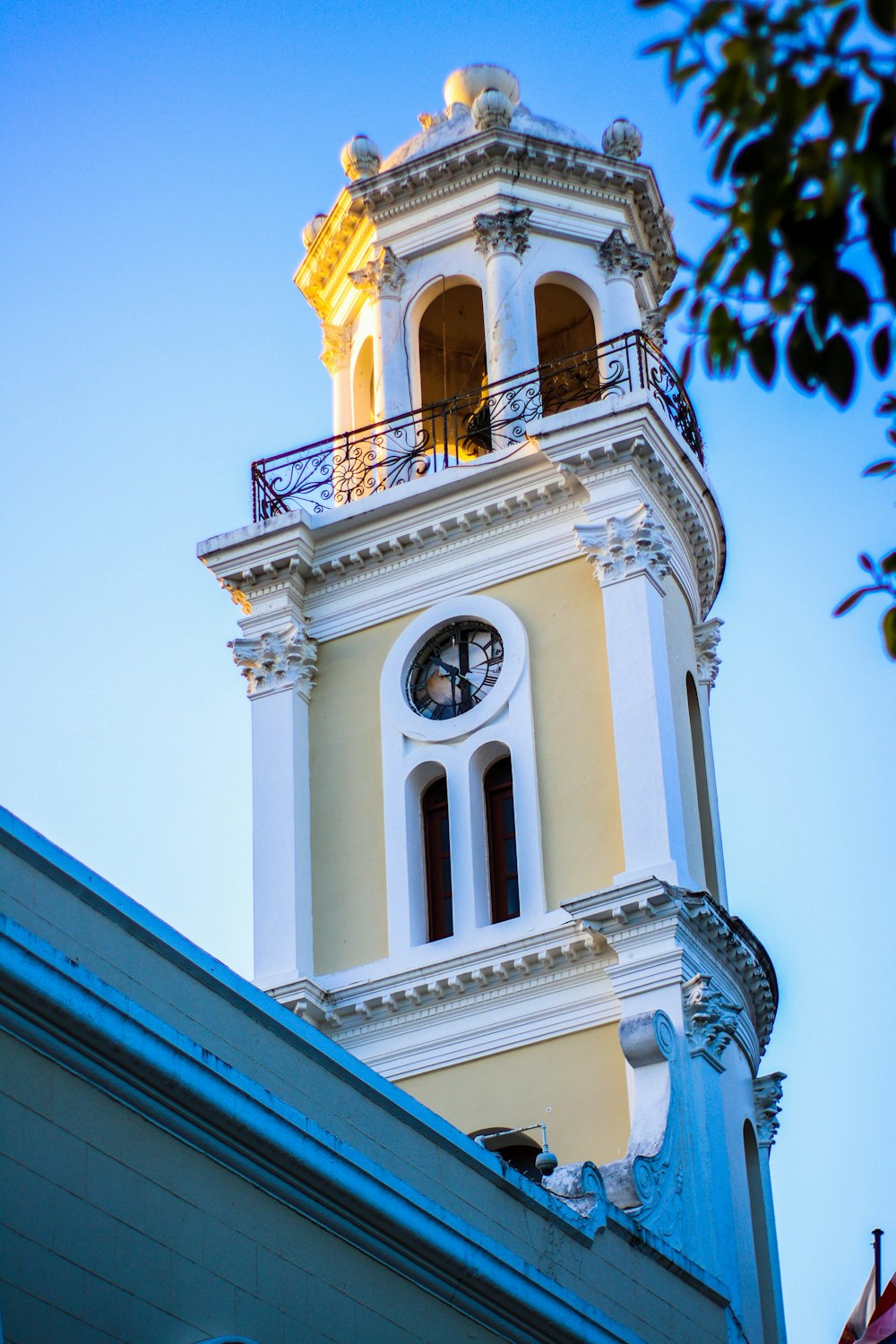 a tall white clock tower with a clock on each of it's sides