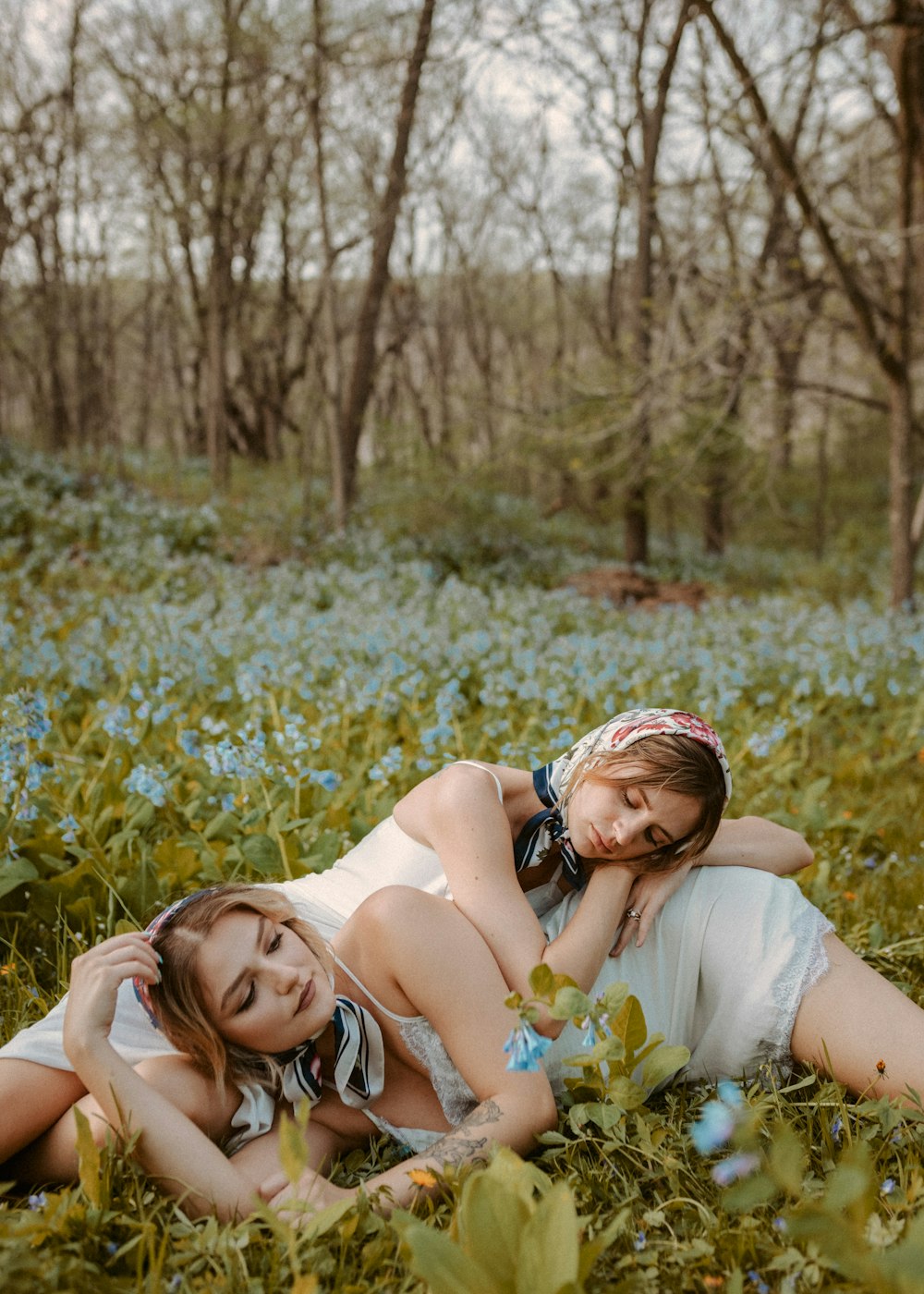 two women laying in a field of blue flowers